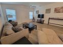 Bright living room with neutral walls, wood-look flooring, comfortable sofa, and plenty of natural light at 1978 Lockett Ln, The Villages, FL 34762