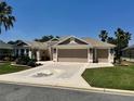Beautiful three-car garage home featuring a unique driveway design with an inlaid turtle mosaic at 1985 Abordale Ln, The Villages, FL 32162