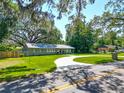 Inviting single-story home featuring a circular driveway, spacious lawn, and mature shade trees at 203 Se 30Th Ave, Ocala, FL 34471