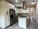 Bright kitchen featuring white cabinetry, stainless steel appliances, and a granite island at 217 S East St, Leesburg, FL 34748