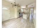 Modern kitchen featuring white cabinets, stainless steel appliances, granite countertops, and stylish lighting fixture at 217 S East St, Leesburg, FL 34748