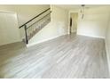 Open living room with staircase, light wood-look tile flooring, and abundant natural light at 217 S East St, Leesburg, FL 34748