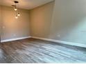 Spacious living room with sleek wood-look flooring and modern lighting fixtures at 217 S East St, Leesburg, FL 34748