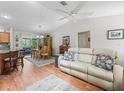 Bright living room with hardwood floors, vaulted ceiling, and seamless flow into the dining and kitchen areas at 2259 Lockwood Loop, The Villages, FL 32162