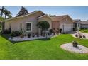 Beautifully landscaped front yard with vibrant green grass, decorative stones, and a variety of potted plants at 24436 Madewood Ave, Leesburg, FL 34748