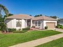Beautiful one-story home with an attached two-car garage, well-maintained lawn and landscaped garden at 25523 Maurepas Ln, Leesburg, FL 34748