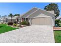 Single Gathering home featuring an extra long brick driveway and two car garage at 3049 Saint Thomas Ln, The Villages, FL 32162