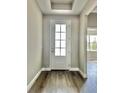 Bright entryway featuring hardwood floors and a stylish front door with glass panels at 3070 Sunscape Ter, Groveland, FL 34736