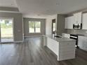 Open-concept kitchen with white cabinetry, stainless steel appliances, and center island at 3070 Sunscape Ter, Groveland, FL 34736