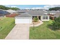 Charming single-story home with a well-maintained lawn, a two-car garage, and manicured landscaping at 3329 Boyd Cir, Oxford, FL 34484