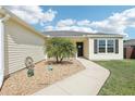 Home's front exterior with a sidewalk leading to the front door and decorative landscape at 3329 Boyd Cir, Oxford, FL 34484