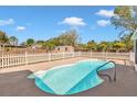 Refreshing backyard pool with clear water, enclosed by a white picket fence and mature landscaping at 3415 Sail Fish Ave, Fruitland Park, FL 34731