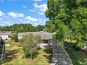 Aerial view of the home with a long driveway and mature trees surrounding the property at 4553 Belle Grv, Leesburg, FL 34748