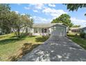 Charming single-story home with a well-manicured lawn, attached garage, and inviting front entrance at 4553 Belle Grv, Leesburg, FL 34748
