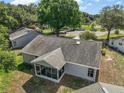 Back of house with a screened-in porch, overlooking the backyard, and mature landscaping at 4553 Belle Grv, Leesburg, FL 34748