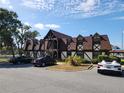 View of a tudor-style building with a meticulously maintained parking area at 500 Newell Hill Rd # D, Leesburg, FL 34748