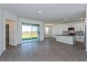 Spacious open-concept living area features wood-look tile and sliding glass doors to the outside at 5031 Abigail Dr, Lake Wales, FL 33859