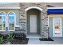 Inviting front entryway with a stone archway and a classic, paneled front door at 5039 Abigail Dr, Lake Wales, FL 33859