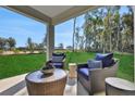 Comfortable covered patio area with stylish outdoor seating and a view of the expansive yard at 5039 Abigail Dr, Lake Wales, FL 33859