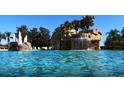 Resort-style pool with cascading waterfall and lush tropical landscaping at 5373 Compass Pt # 1, Oxford, FL 34484