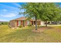 Charming house with manicured lawn, complemented by colorful landscaping and trees, with a view at 597 Skyridge Rd, Clermont, FL 34711