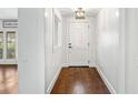 Bright foyer with hardwood floors, white walls, and stylish light fixture at 657 Riverpark Cir, Longwood, FL 32779