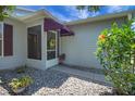Inviting front porch with a screened entrance, awning, and beautiful landscaping at 830 Grand Vista Trl, Leesburg, FL 34748