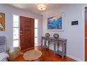 Inviting foyer showcasing a wood door, console table with decorative accents, and hardwood floors at 910 Locust St, New Smyrna Beach, FL 32169