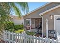 Exterior of a charming home showcasing a screened-in porch, with seating and well-manicured landscaping at 992 Pinewood Pl, The Villages, FL 32162