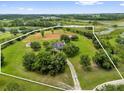 Expansive aerial view of property showcasing lush greenery and surrounding landscape with lakes and trees at 10901 Island Grove Rd, Clermont, FL 34711
