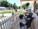 Inviting front porch with comfortable seating, lush potted plants, and a view of the peaceful neighborhood at 11250 Sw 78Th Ct, Ocala, FL 34476