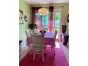 Cozy dining room with white table and chairs, decorative chandelier, and bright pink rug at 14657 Sw 41St Ave, Ocala, FL 34473