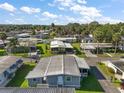 Bright aerial shot showcases a well-maintained mobile home community, lush trees, and homes under sunny skies at 150 Hickory Ln, Eustis, FL 32726
