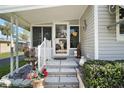 Charming front entrance with steps, a decorated screen door, and well-maintained landscaping at 150 Hickory Ln, Eustis, FL 32726