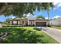 Beautiful one-story home with well-kept lawn, a two-car garage, and an inviting front entrance at 1554 Sarus Ave, Groveland, FL 34736
