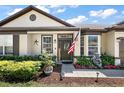 Close-up view of a home's front door with decorative plants and an American flag at 1554 Sarus Ave, Groveland, FL 34736