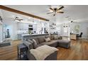 Spacious living room with a large sectional couch, hardwood floors, and abundant natural light at 1554 Sarus Ave, Groveland, FL 34736