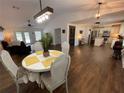 Open-concept dining area featuring a round table, stylish chairs, and hardwood floors with views of the living and kitchen areas at 1650 Sundance Dr, St Cloud, FL 34771