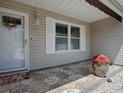 A welcoming front porch with decorative wreath, window, and beautiful stone flooring at 17374 Se 76Th Flintlock Ter, The Villages, FL 32162