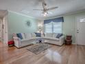 Bright living room with hardwood floors, stylish furnishings, and plenty of natural light at 17374 Se 76Th Flintlock Ter, The Villages, FL 32162