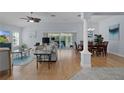 Bright living room featuring hardwood floors, neutral walls, elegant furnishings, and sliding glass doors to lanai at 1754 Pennecamp Dr, The Villages, FL 32162