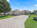 Charming exterior elevation showcasing landscaped curb appeal and brick-paved driveway at 17787 Se 114Th Ave, Summerfield, FL 34491