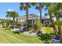 Lush backyard featuring a pergola-covered patio, well-maintained lawn, and tropical landscaping provides a serene outdoor space at 2001 Dagenais Way, The Villages, FL 32163