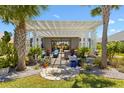 Beautiful outdoor patio with a pergola, stone flooring, and tropical landscaping creates a relaxing backyard retreat at 2001 Dagenais Way, The Villages, FL 32163