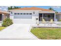 Charming exterior of a single-story home with a white picket fence and landscaped front yard at 2063 Thornton Ter, The Villages, FL 32162