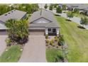 Charming single-story home featuring a well-manicured lawn and a brick driveway, complete with a two-car garage at 2129 Palm Tree Dr, Poinciana, FL 34759
