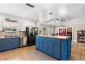 Open kitchen featuring a blue island, stainless steel appliances, and a view of the dining area at 2252 Kent Rd, Deltona, FL 32738