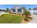 Well-manicured lawn and landscaping featuring trimmed bushes and palm trees accentuates the beauty of the property at 2403 Muirwood Pl, The Villages, FL 32162