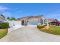 Charming single-story home featuring a two-car garage and a well-maintained front yard with white picket fence at 2403 Muirwood Pl, The Villages, FL 32162