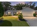 Beautiful single-story home featuring lush landscaping and an attached two-car garage at 2482 Ansley Path, The Villages, FL 32162